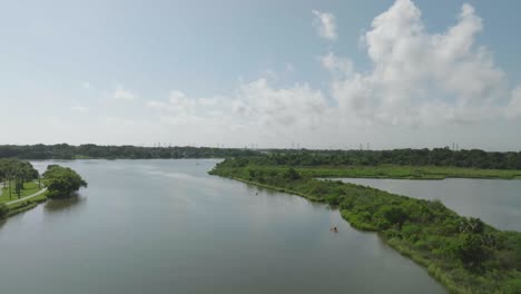 An-aerial-drone-view-of-2-kayakers-paddling-down-Clear-Creek-in-Nassau-Bay,-Texas