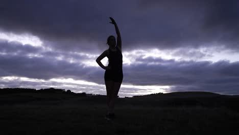 Silhouette-of-young-woman-stretching-at-sunrise