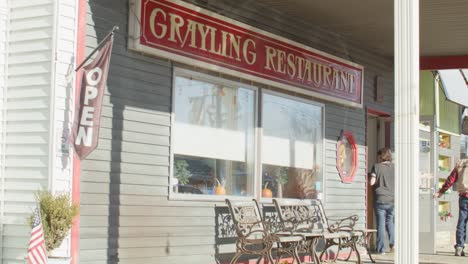 Grayling-Restaurant-in-Grayling,-Michigan-with-people-walking-out-and-stable-video-shot
