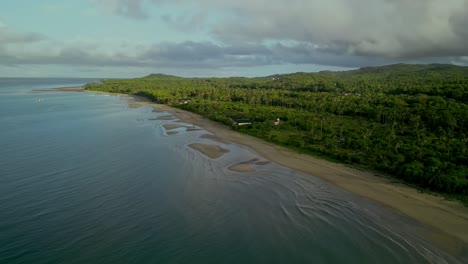 Wide-aerial-pan-of-beach-and-green-coastal-landscape-in-Philippines