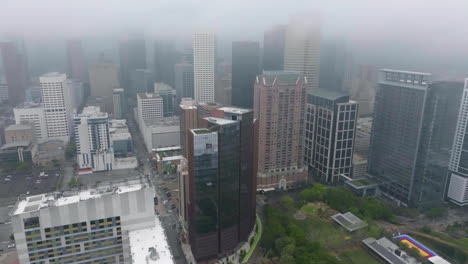 Drone-shot-around-the-Houston-city-skyline,-foggy-day-in-Texas,-USA