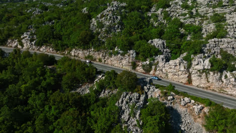 Aerial-pan-shot-following-traffic-in-the-highlands-of-Budva,-summer-in-Montenegro