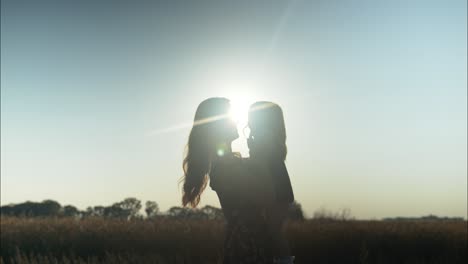 Happy-mother-and-daughter-silhouette,-together-outside-in-summer-sunset-having-positive,-loving-family,-parenting-or-mothers-day-moment-in-cinematic-slow-motion-depicting-joys-of-motherhood