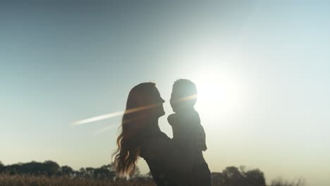 Happy,-smiling-mother-and-son-silhouette,-together-outside-in-summer-sunset-having-positive,-loving-family,-parenting-or-mothers-day-moment-in-cinematic-slow-motion-depicting-joys-of-motherhood