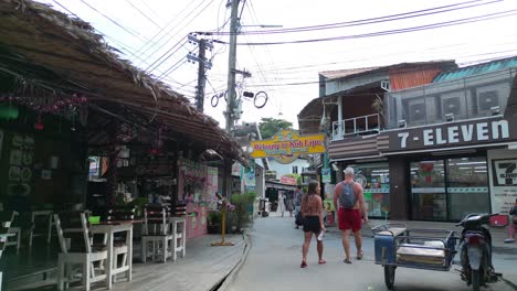 7-eleven-Tuk-Tuks-Conduciendo-Por-Una-Estrecha-Calle-Peatonal-Llena-De-Tiendas-Y-Casas-Koh-Lipe-Asia