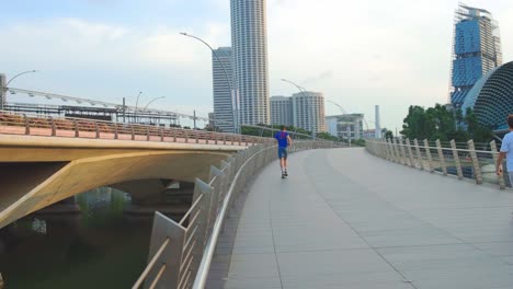 Un-Joven-Con-Ropa-Deportiva-Haciendo-Ejercicio-A-Través-Del-Puente-En-La-Ciudad-Urbana-En-La-Mañana-De-Verano