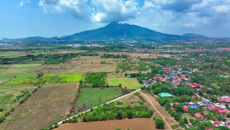 Pequeña-Ciudad-Con-Una-Colorida-Azotea-En-La-Zona-Rural-De-La-Isla-De-Biliran,-Filipinas,-Un-Volcán-Gigante-Al-Fondo