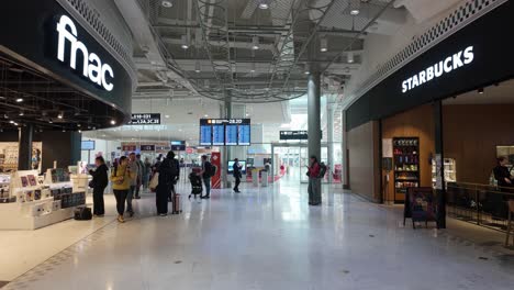 People-pass-towards-the-security-gates-in-the-Charles-de-Gaulle-airport-terminal-two-in-Paris,-France