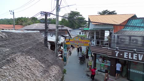 tuk-tuks-driving-down-a-narrow-walkingstreet-lined-with-shops-and-homes-koh-Lipe-asia