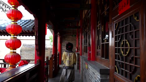 Retrovisor-De-Una-Chica-Asiática-Qing-Con-Ropa-Tradicional-Caminando-Bajo-Un-Balcón-Chino-Y-Faroles-Rojos