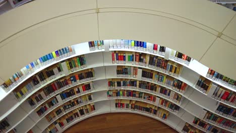 A-Slow-Pan-Across-A-Direct-Top-View-Of-A-Row-Of-Library-Bookshelf-In-A-Wooden-Aisle