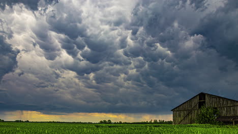 Ein-Faszinierender-Zeitraffer,-Der-Die-Bewegung-Dramatischer-Wolken-über-Einer-Rustikalen-Scheune-Festhält