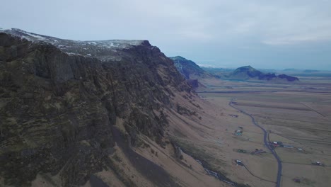 Aerial-landscape-view-of-icelandic-mountains,-with-melting-snow,-on-a-moody-evening