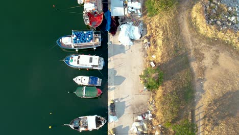 Vista-Aérea-De-Pájaro-De-Barcos-Pesqueros-Atracados-En-El-Puerto,-Kavala-Perigiali-Grecia