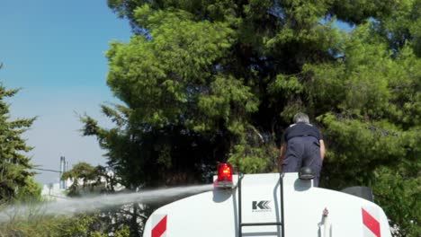 Slow-motion-footage-of-municipality-crew-spraying-water-at-pine-trees-in-order-to-prevent-spread-of-forest-fire,-Parnitha-forest,-Greece