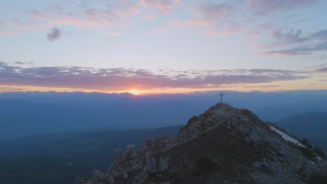 Drone-shot-of-a-man-running-on-a-mountain-ridge-at-sunset