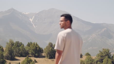 Solo-traveler-immerses-in-the-serene-beauty-of-Zaamin,-with-towering-mountains-in-the-background