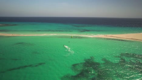 Kitesurfer-Gleitet-über-Türkisfarbenes-Wasser-In-Der-Nähe-Von-Sandy-Cay,-Aufgenommen-Per-Drohne