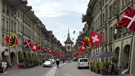 Swiss-Flags-on-historic-buildings-in-main-street-of-Bern-City,-Switzerland