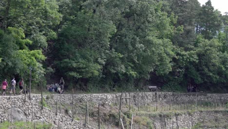 Hikers-walk-along-part-of-the-irrigation-channel-hiking-path-above-Algund---Lagundo,-South-Tyrol,-Italy