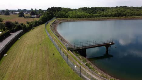 Water-supply-reservoir-aerial-view-circling-rural-establishing-idyllic-countryside-lake-supply