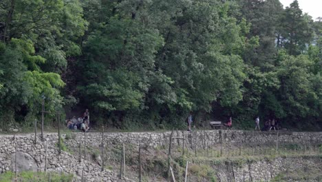 Hikers-walk-along-part-of-the-irrigation-channel-hiking-path-above-Algund---Lagundo,-South-Tyrol,-Italy