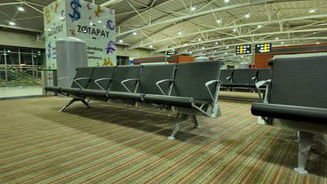 Empty-seating-area-at-Larnaka-Airport-in-Cyprus-with-visible-duty-free-shopping-bag-and-modern-architecture