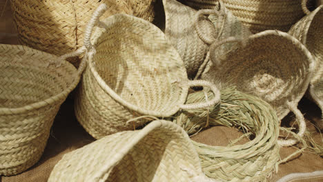 Beautiful-shot-of-a-group-of-handmade-baskets-made-with-yellow-straw-at-a-stand-inside-a-medieval-fair-in-Andalusia,-Spain