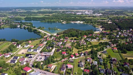 Na-Piaskach-Reservoir-with-blue-waters,-green-landscapes,-and-surrounding-residential-area