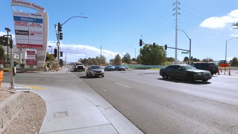 Stock-footage-of-a-sunny-Las-Vegas-suburban-intersection,-showcasing-cars,-traffic-lights,-and-surro