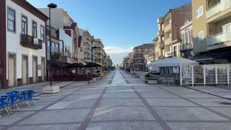 Quiet-and-beautiful-morning-street-view-of-typical-Portuguese-houses,-cafes,-and-restaurants-in-Praia-do-Furadouro,-Ovar,-Portugal