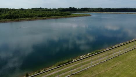 Water-supply-reservoir-platform-aerial-view-dolly-across-rural-idyllic-countryside-lake-supply