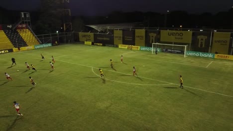 Children's-tournament-on-a-regulation-field-with-official-referees,-both-teams-competing-for-the-ball