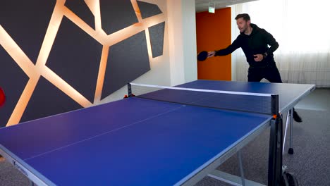 Footage-of-two-people-playing-ping-ping-in-an-office-space-during-a-break-from-work-in-the-day-time-shot-in-4K