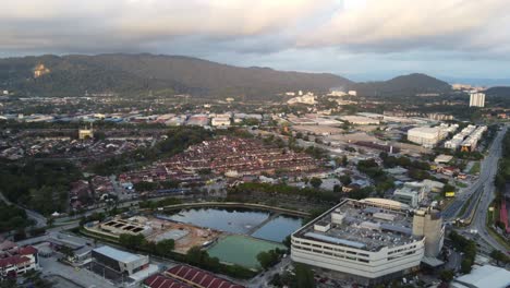 Lenta-Toma-De-Puesta-De-Sol-Moviéndose-Hacia-Atrás-Revelando-Una-Pequeña-Ciudad-En-Malasia-Con-Un-Centro-Comercial