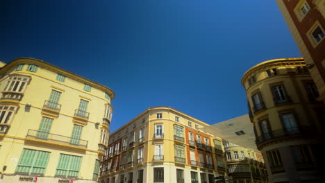 Classic-European-buildings-with-colorful-facades-against-a-clear-blue-sky-in-Malaga's-historic-district