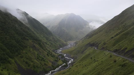 Un-Tranquilo-Río-De-Montaña-Que-Fluye-A-Través-De-Un-Exuberante-Valle