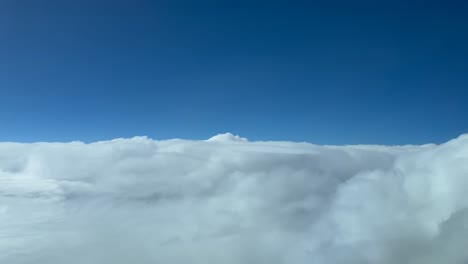 Aerial-pilot-POV-flying-over-stormy-white-clouds-with-a-deep-blue-sky