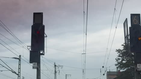 Vista-Del-Conductor-Del-Tren-De-Una-Señal-Roja-Al-Anochecer,-Con-Líneas-Aéreas-Y-Varias-Señales-Ferroviarias