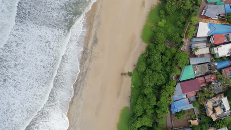 Shoreline-of-Varkala-Cliff-Beach,-drone-view-of-Varkala-beach-from-the-top-of-the-cliff-also-known-as-Papanasham-Beach,-Thiruvananthapuram,-Kerala,-India