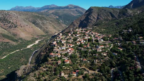 Pueblo-Tranquilo-Con-Vida-Sencilla,-Lejos-Del-Ruido-De-La-Ciudad,-Se-Eleva-Sobre-Una-Colina-Rocosa-Rodeada-De-Montañas-En-Albania,-Efecto-Vértigo