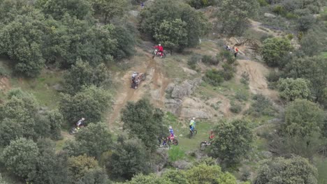 Flug,-Der-Die-Vorbereitungen-Für-Eine-Motocross-Meisterschaft-Am-Morgen-Auf-Dem-Feld-Beobachtet,-Wo-Es-Ziemlich-Viele-Teilnehmer-Mit-Motorrädern-Gibt,-Die-Einen-Erddamm-Hinaufklettern,-Um-Sich-Vorzubereiten