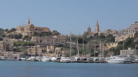 View-of-boats-docked-along-the-coastline-of-Gozo's-Mgarr-Harbour-in-Malta-on-a-sunny-day,-capturing-the-essence-of-travel-and-vacation