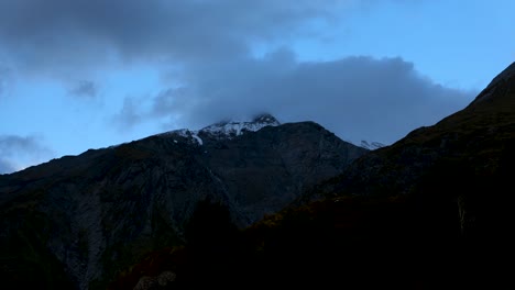 Timelapse-of-clouds-running-above-a-mountain-during-sunset-on-a-sunny-day-in-Rees-Dart-track,-New-Zealand