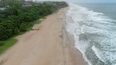 Shoreline-of-Varkala-Cliff-Beach,-drone-view-of-Varkala-beach-from-the-top-of-the-cliff-also-known-as-Papanasham-Beach,-Thiruvananthapuram,-Kerala,-India