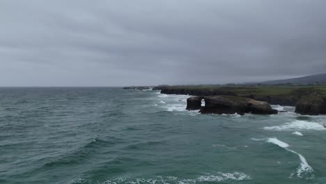 Tide-in-drone-flying-along-sea-cliffs-As-Catedrais-,-Cathedrals-beach-Northern-Spain