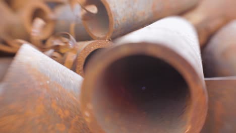 Close-up-of-rusted-metal-pipes-and-scrap,-panning-shot-captures-textures-and-details