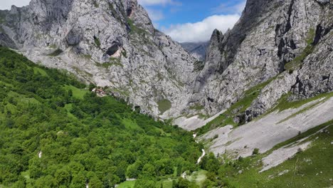 Pull-back-drone-aerial-reverse-reveal-Bulnes-mountain-village-Picos-de-Europa,-Spain