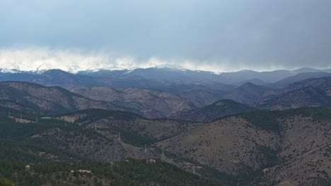 Panoramic-aerial-estabilshing-overview-of-sweeping-valleys-covered-and-dotted-with-evergreen-trees-under-stormy-sky