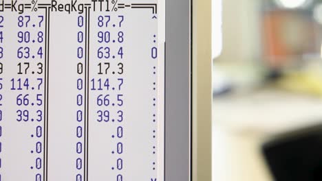 Close-up-view-of-a-computer-screen-displaying-cost-and-rate-data-in-blue-text
